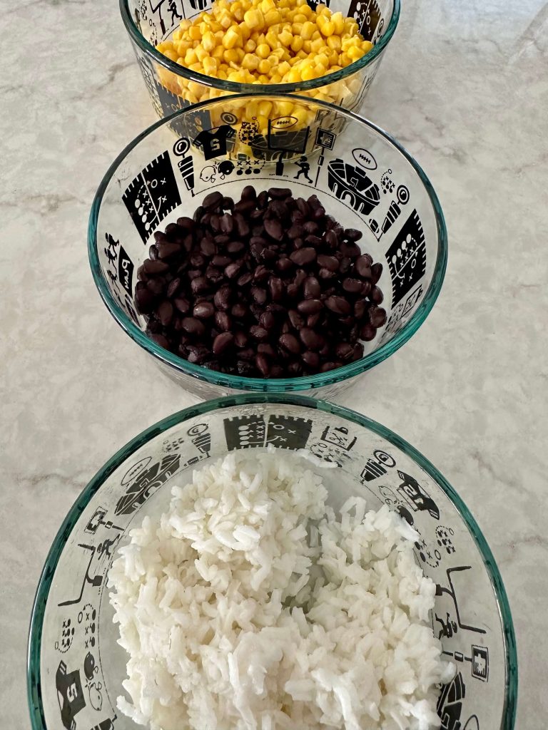 White rice, black beans and corn in glass bowls