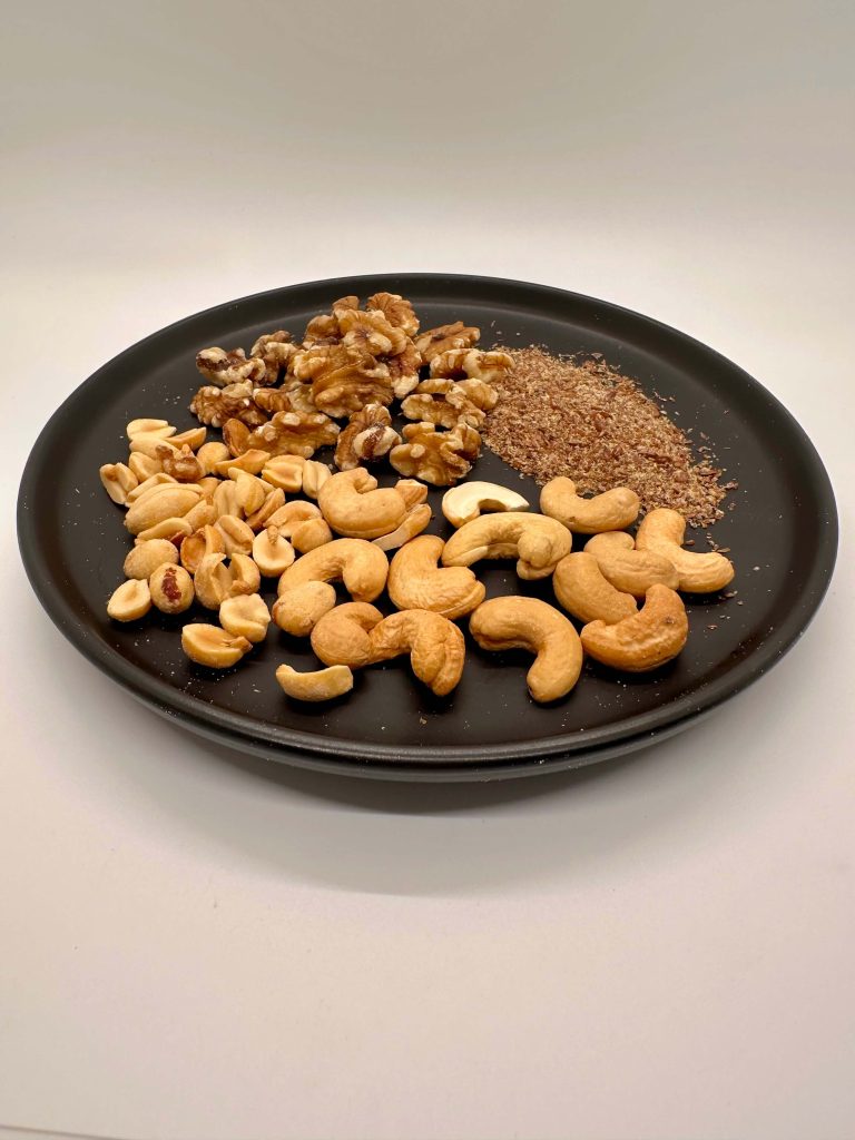 peanuts, walnuts, flaxseed, and cashews on a plate